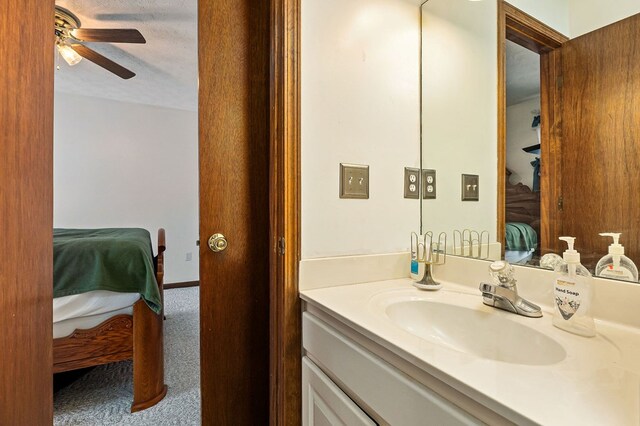 bathroom with baseboards, a ceiling fan, ensuite bathroom, a textured ceiling, and vanity