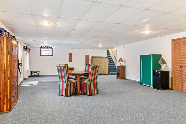 dining room with baseboards, carpet flooring, a drop ceiling, and stairs