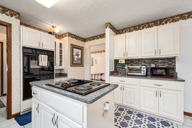 kitchen with dark countertops, white cabinets, black appliances, and wallpapered walls