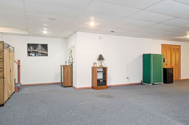 below grade area featuring stairway, a drop ceiling, carpet flooring, and baseboards