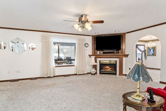 living area with arched walkways, ornamental molding, a wealth of natural light, and light colored carpet