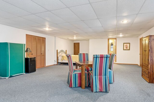 dining room featuring carpet, a paneled ceiling, and baseboards