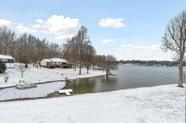 yard layered in snow featuring a water view