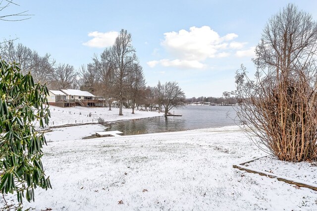 yard covered in snow featuring a water view