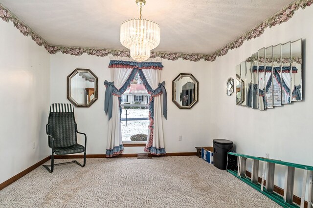 sitting room with an inviting chandelier, baseboards, a textured ceiling, and light colored carpet