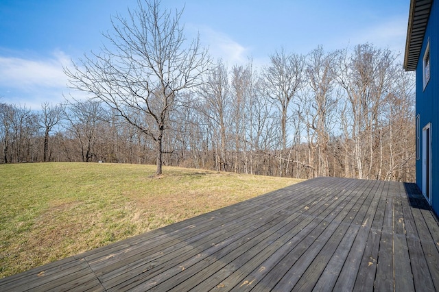 wooden deck featuring a forest view and a yard