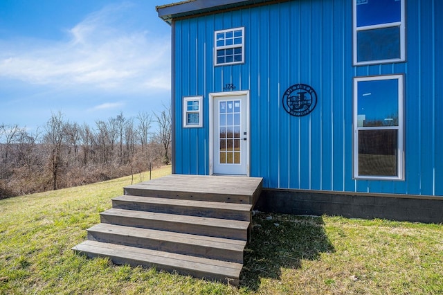 doorway to property featuring a yard and board and batten siding