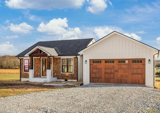 view of front facade featuring a garage, roof with shingles, driveway, and board and batten siding