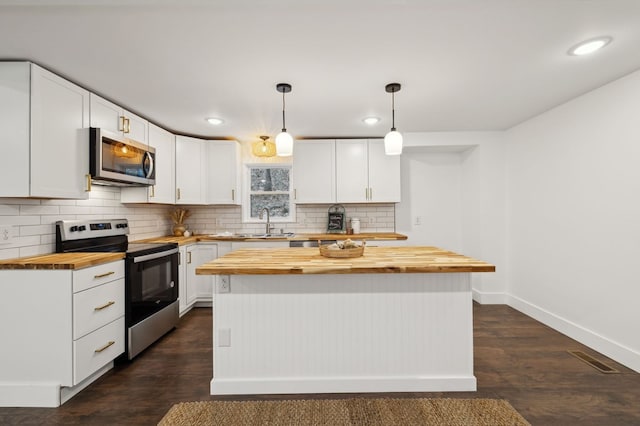 1069 Pleasant Shade Hwy, Pleasant Shade, TN 37145 - kitchen with wood counters, stainless steel appliances, white cabinetry, decorative backsplash, and recessed lighting