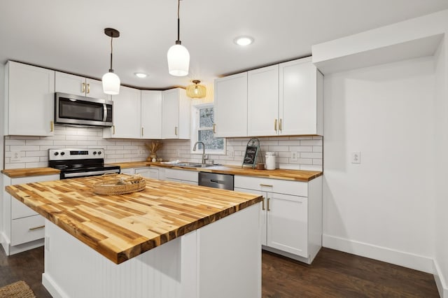 1069 Pleasant Shade Hwy, Pleasant Shade, TN 37145 - kitchen with butcher block countertops, appliances with stainless steel finishes, dark wood-type flooring, white cabinets, and backsplash
