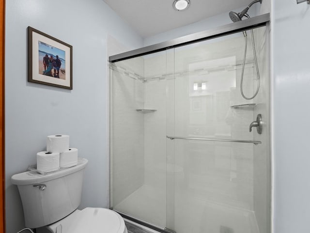 full bath featuring a shower stall and toilet