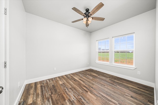 unfurnished room with dark wood-type flooring, baseboards, and a ceiling fan