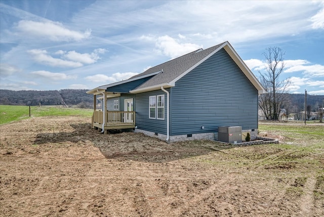 view of property exterior with roof with shingles, crawl space, and cooling unit