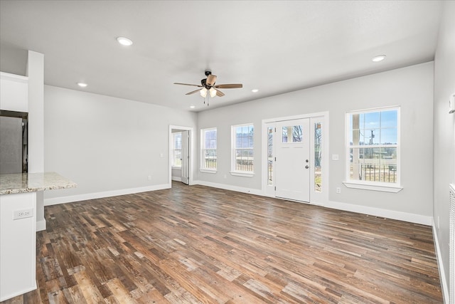 unfurnished living room with baseboards, dark wood finished floors, and recessed lighting