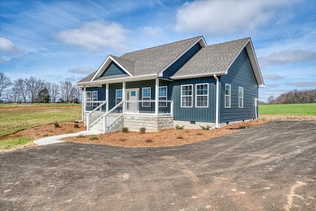 view of front facade featuring a shingled roof, crawl space, and a porch