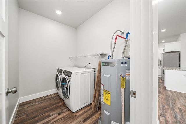 laundry room featuring dark wood-style floors, laundry area, washing machine and dryer, and electric water heater