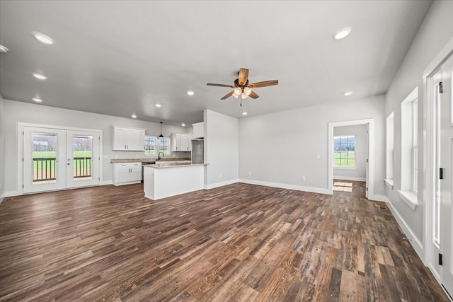 unfurnished living room featuring recessed lighting, dark wood-style flooring, baseboards, and french doors