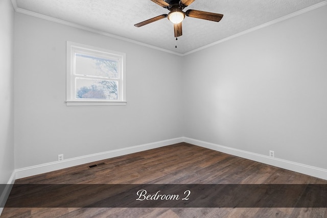 empty room featuring dark wood-style floors, visible vents, crown molding, and a textured ceiling