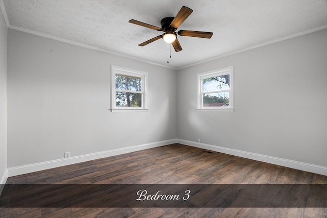 empty room featuring ornamental molding, dark wood-style flooring, plenty of natural light, and baseboards