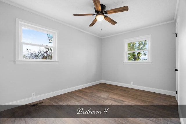 unfurnished room featuring crown molding, dark wood-style flooring, visible vents, and baseboards