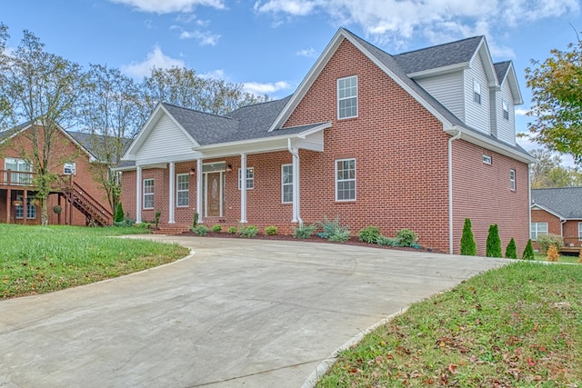 view of front of property featuring a porch, brick siding, a shingled roof, stairs, and a front lawn