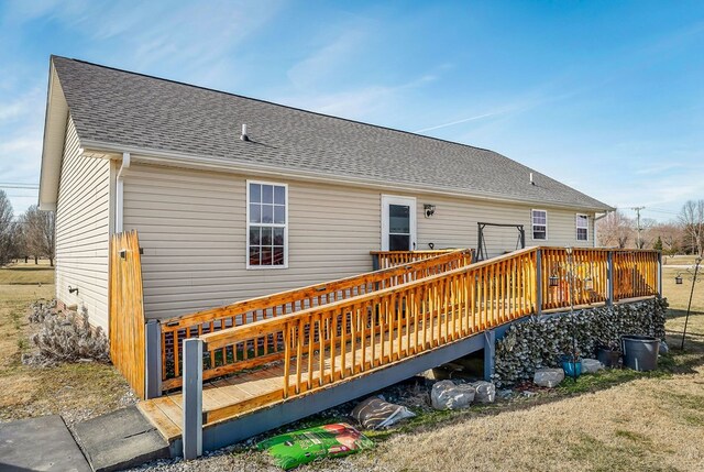 back of house with a shingled roof and a wooden deck