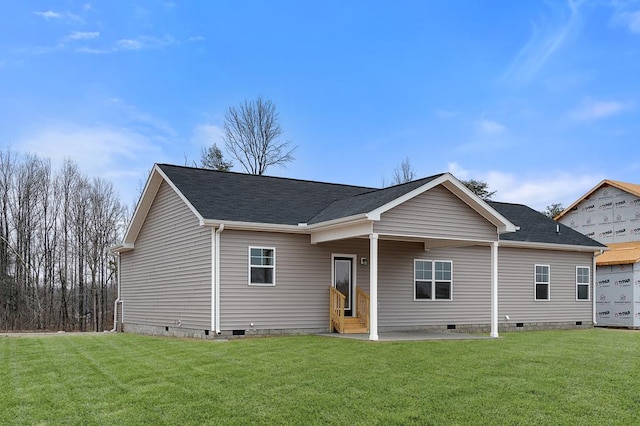 back of property featuring roof with shingles, crawl space, a patio area, and a lawn