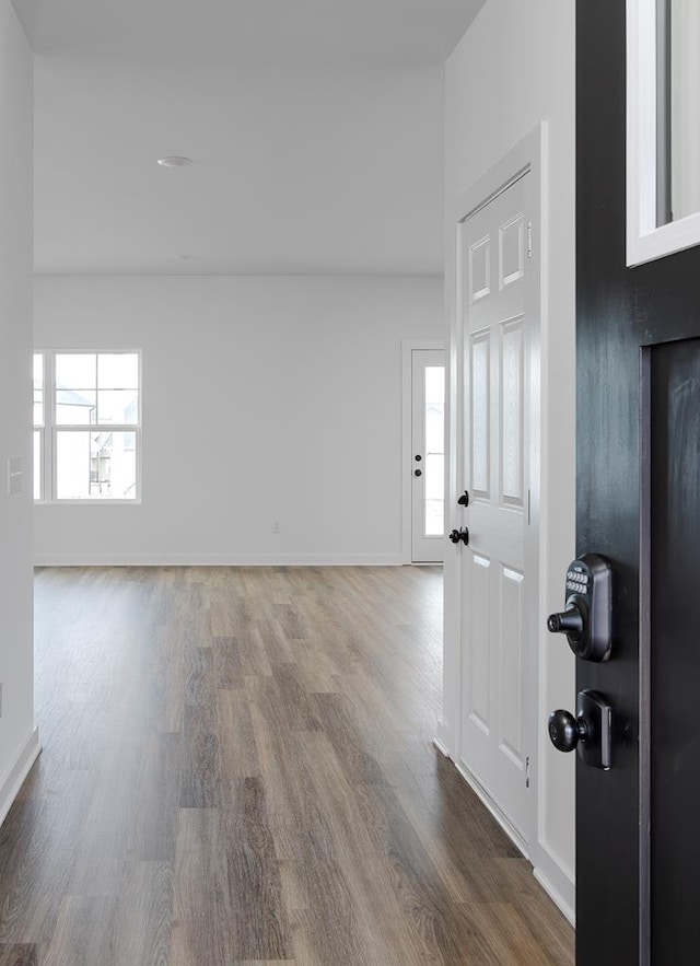 empty room with a healthy amount of sunlight, baseboards, and wood finished floors