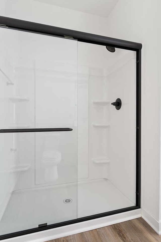 bathroom featuring a stall shower and wood finished floors