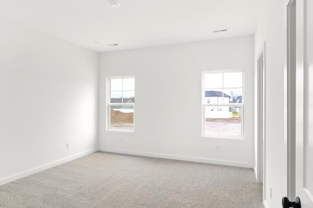 unfurnished room with light carpet, baseboards, and visible vents