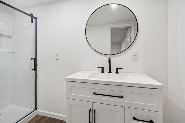 full bath featuring a shower stall, vanity, and wood finished floors