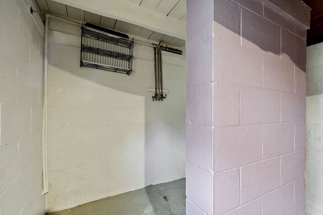 interior details featuring concrete block wall and unfinished concrete flooring