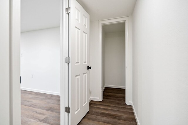 hall with baseboards and dark wood-style flooring