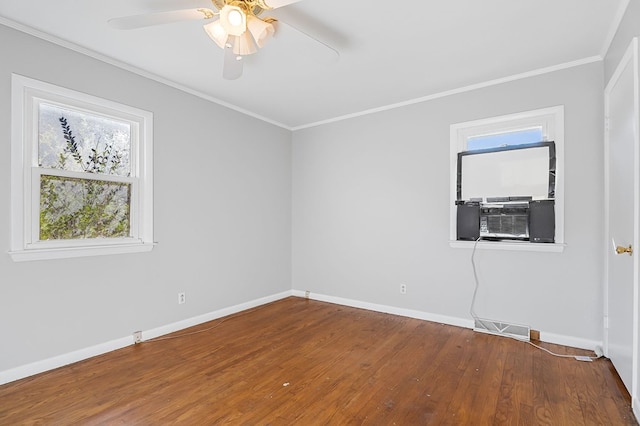 empty room featuring visible vents, baseboards, ornamental molding, wood finished floors, and a ceiling fan