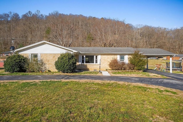 ranch-style house featuring driveway, brick siding, and a front lawn