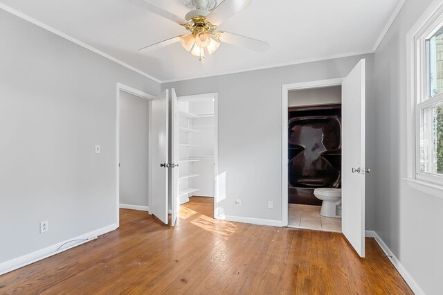 unfurnished bedroom with baseboards, ornamental molding, and hardwood / wood-style flooring