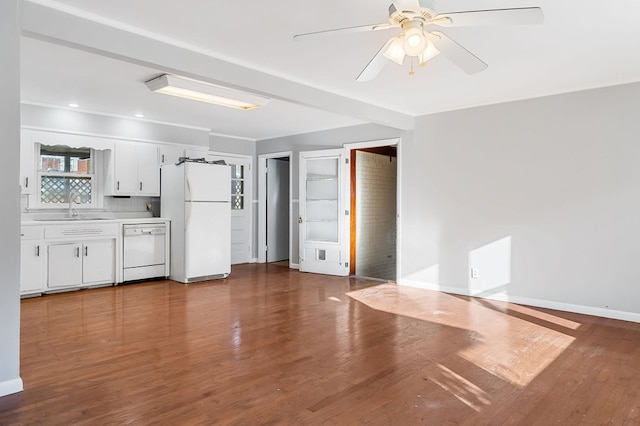 interior space with a sink, baseboards, a ceiling fan, and dark wood-style flooring