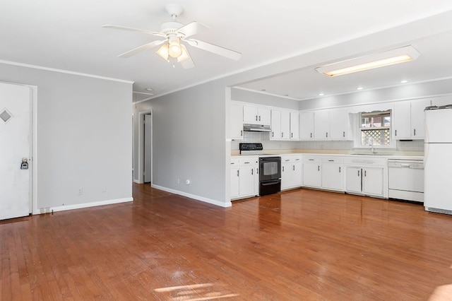 kitchen with under cabinet range hood, white appliances, ornamental molding, and light countertops