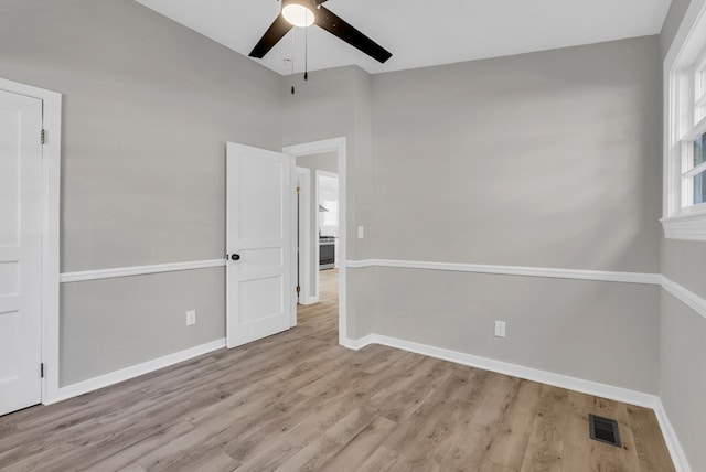 empty room featuring visible vents, baseboards, and light wood-style floors