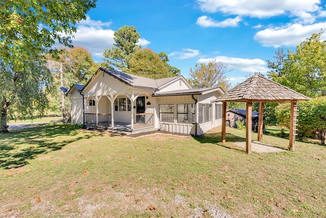 rear view of property with a gazebo, a yard, and a sunroom