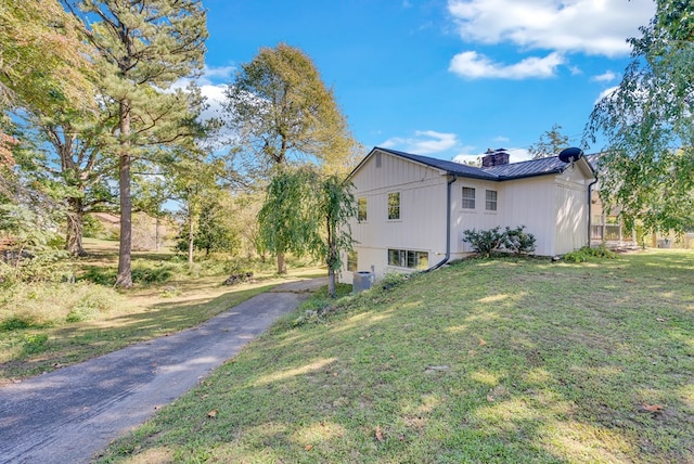 view of property exterior with a chimney and a yard