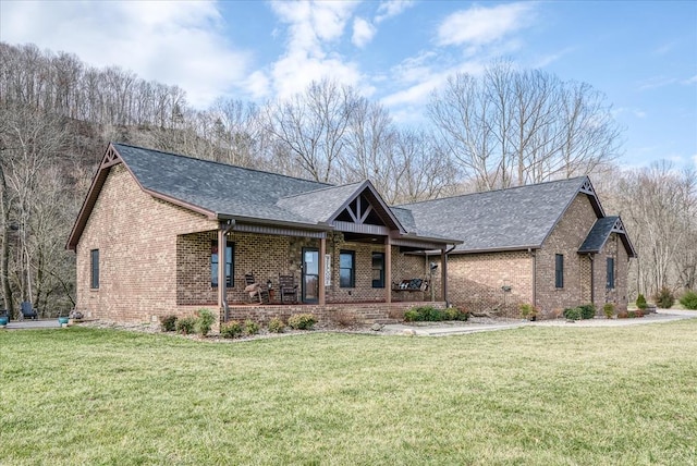 view of front of home with covered porch, brick siding, and a front lawn