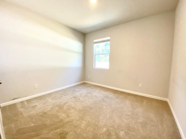 carpeted spare room featuring baseboards