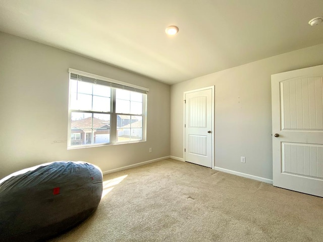 living area featuring carpet and baseboards