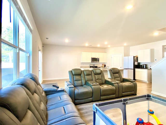 living area featuring recessed lighting, light wood-style flooring, and baseboards