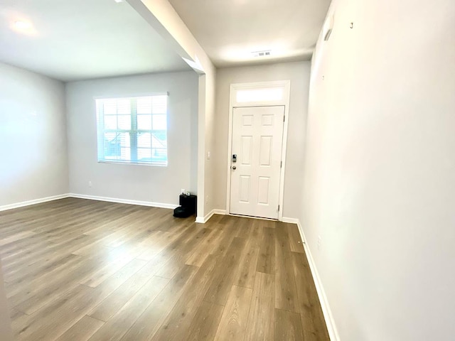 foyer entrance with wood finished floors, visible vents, and baseboards