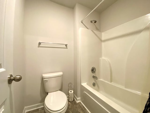 full bathroom featuring toilet, washtub / shower combination, and baseboards