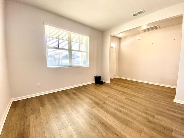 empty room with visible vents, baseboards, and wood finished floors