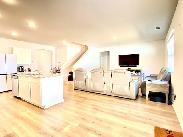 living room with recessed lighting, visible vents, and light wood finished floors