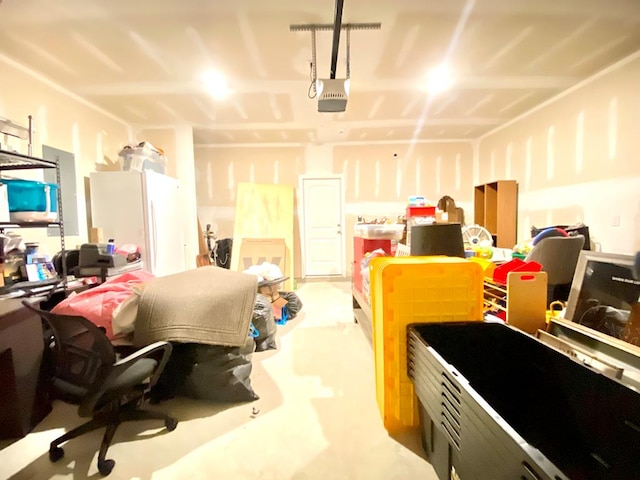 garage featuring freestanding refrigerator and a garage door opener